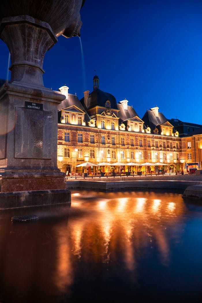 Captivating view of a neoclassical building and fountain illuminated at dusk in a town square.